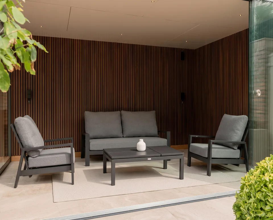 A lounge set with armchairs and a coffee table under a canopy